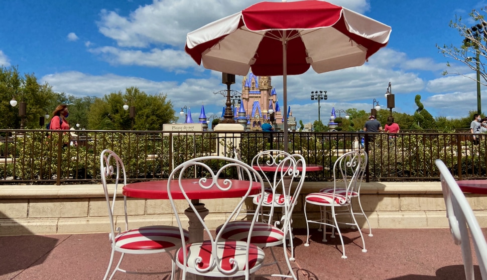 Outdoor table and seating at Disney's Magic Kingdom in front of castle.