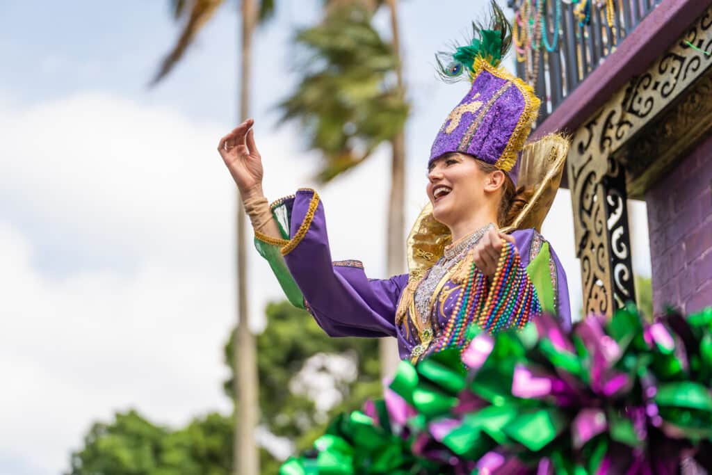 Woman throwing beads at Busch Gardens Mardi Gras